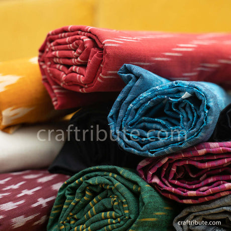 Colourful pochampally Double Ikat Dress materials and dupattas stacked together