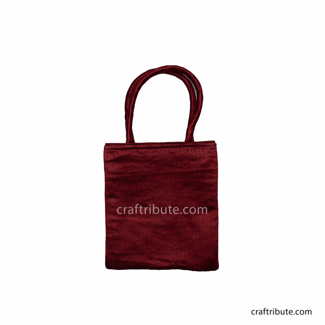 Back side of a red hand bag showcasing Pakko Kutch Embroidery