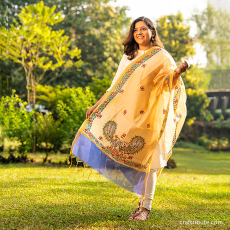 A girl wearing a Madhubani hand painted dupatta with blue border and peacock and floral design
