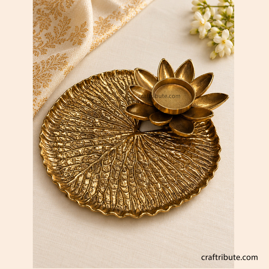 Handcrafted brass lotus leaf tray with a matching lotus diya holder, featuring intricate detailing and an antique gold finish, ideal for festive décor and Diwali gifting.