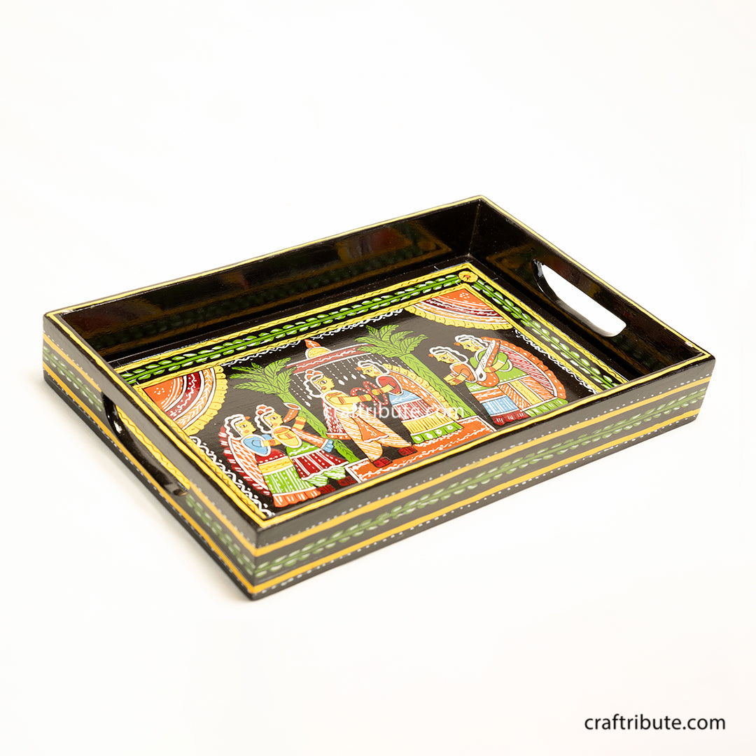 Decorative tray with intricate design depicting a wedding scene on a black background. Hand-painted by women artists from Patna, Bihar, this tray belongs to the beautiful handicraft tradition of Tikuli Art.