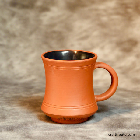 Hand turned terracotta coffee mug with glazed interior. Its elegant shape makes it a perfect gifting choice for personal occasions as well as corporate events.