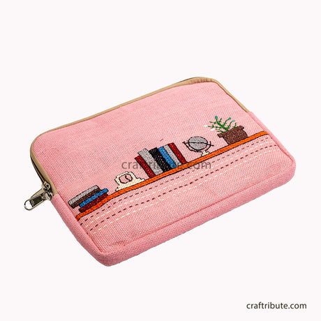 Hand embroidered 15" laptop sleeve depicting a book shelf with books, alarm clock, globe and a planter in attractive baby pink