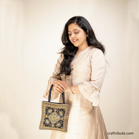 Lady carrying a handbag with Scorpio (Vicchi) design in Kutch 'Neran' Embroidery style, in attractive Black & Gold combination