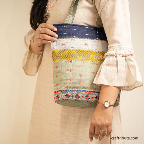Girl holding a Kutch Khudi Sebha, Hand Embroidered Tote Bag with Stripes in attractive Green and Navy blue colour combinations