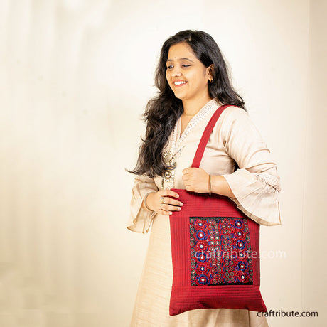 Tote bag showcasing intricate Sindhi Memon embroidery in Red & Blue held by a girl