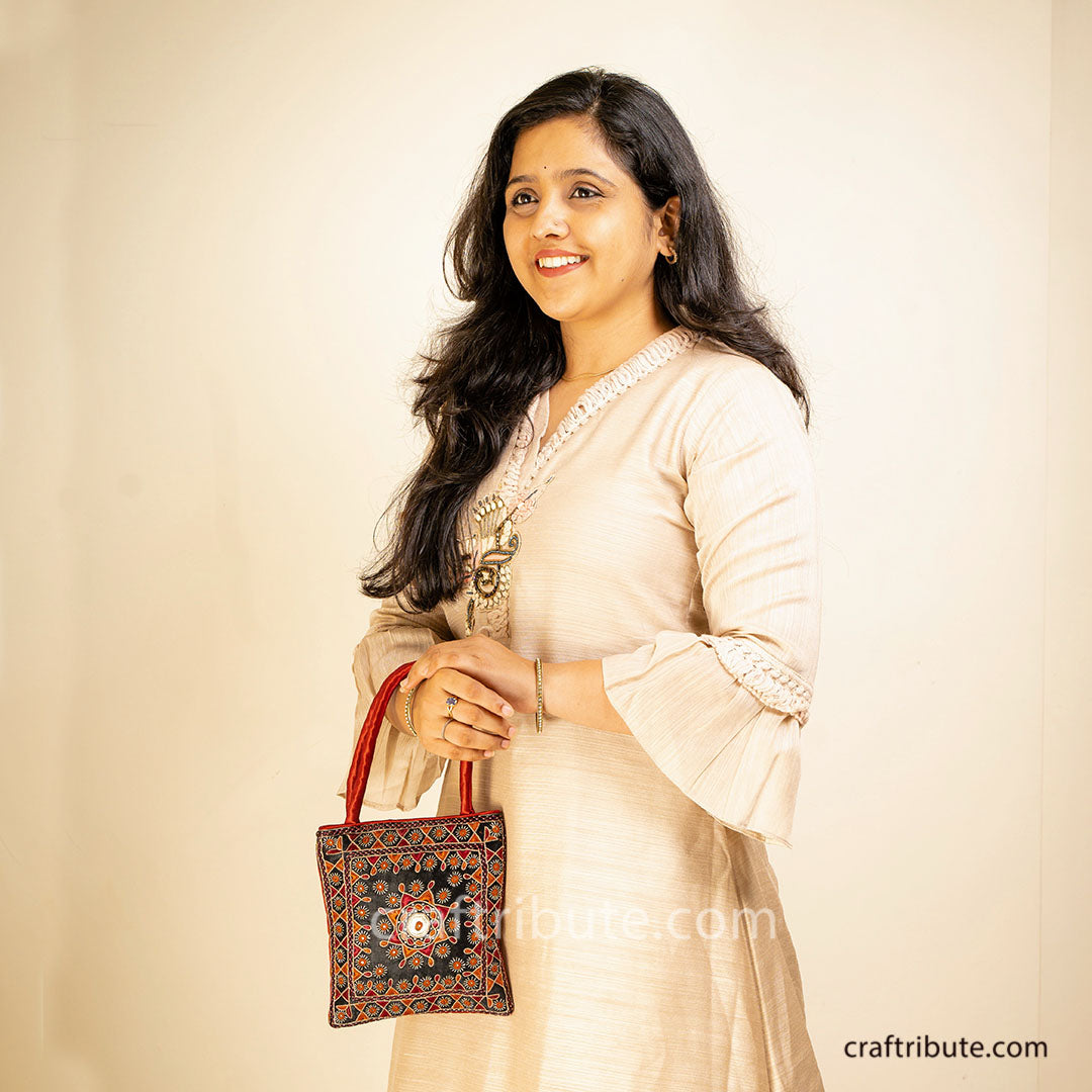 Girl displaying a Pakko Kutch Hand embroidered bag with Shining Star design in black & red