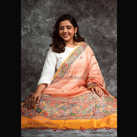 Cotton silk dupatta in duel tone of orange and yellow with intricate fish and floral design. Hand painted by talented grass root artisans from Madhubani, Bihar is a perfect gift for your sister to make her feel special