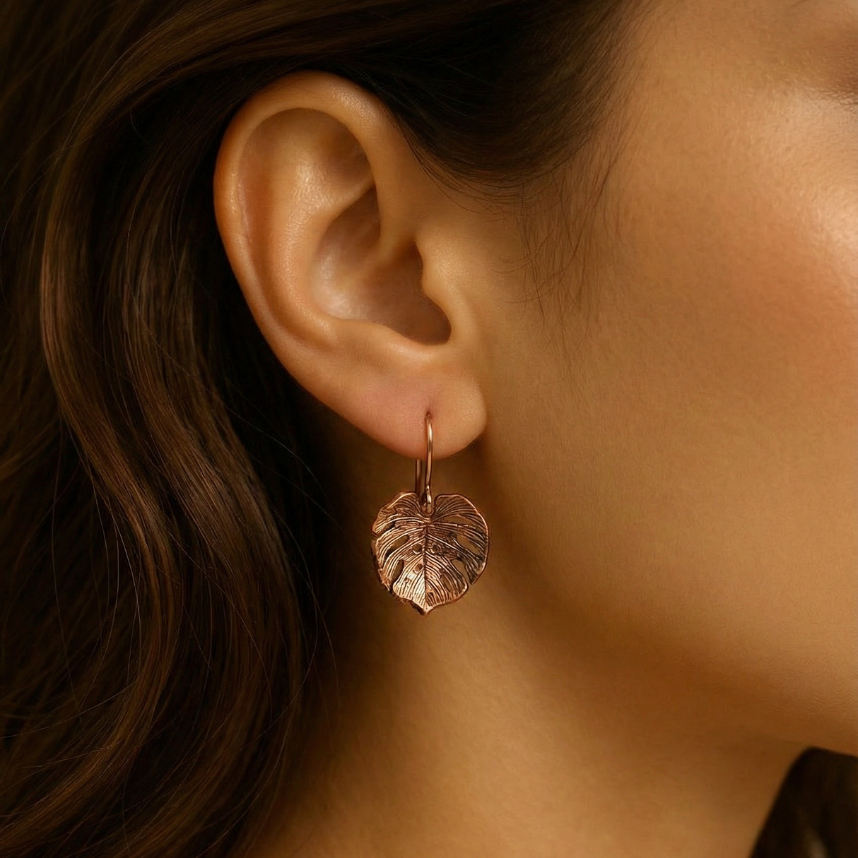 Close-up of a lady wearing a handcrafted copper Monstera leaf-inspired earring