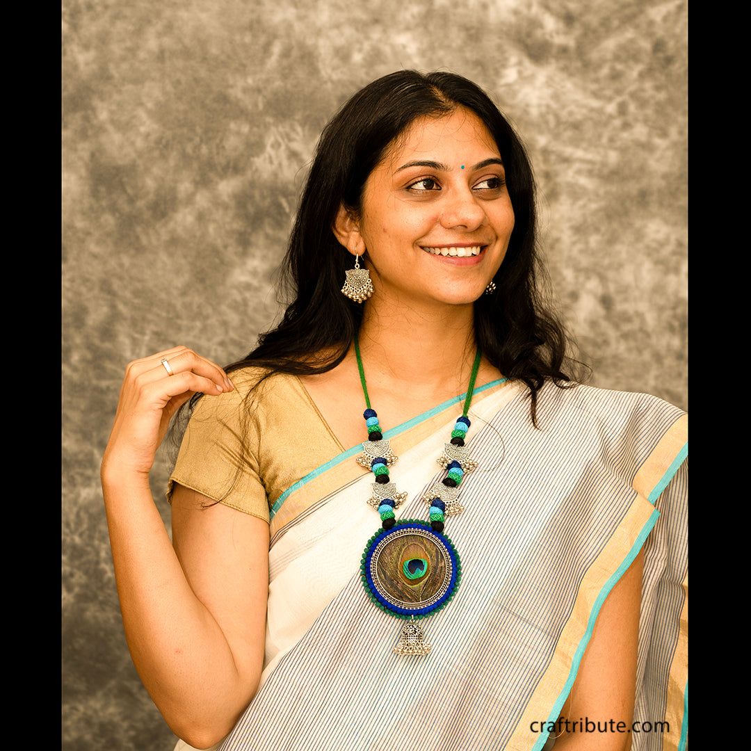 A lady wearing a white chanderi saree with an eye-catching necklace and silver earrings 