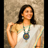A lady wearing a white chanderi saree with an eye-catching necklace and silver earrings 