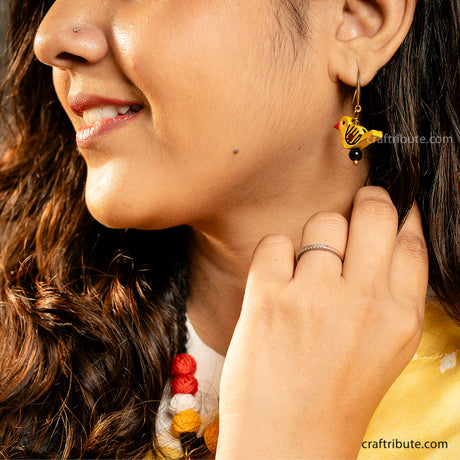 Close up of Bird shaped yellow wooden earrings