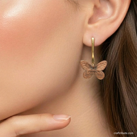 A lady wearing handcrafted copper earrings in butterfly shape