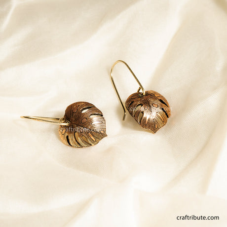 Copper leaf-shaped earrings with intricate texture inspired by Monstera Leaves. Curved outward