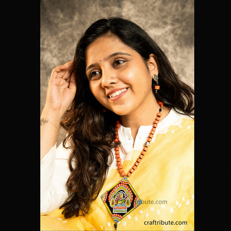 Handcrafted jewellery set comprising of Hand painted Tikuli Art Wooden Pendant strung with orange and silver beads & Matching earring