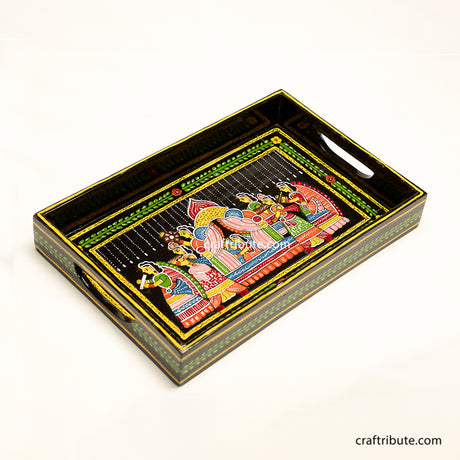 Hand painted wooden tray with an intricate design depicting an indian bride being carried in a paliquiin. Vibrant colours on a black surface makes it very festive and a beautiful gifting option for wedding ceremonies.