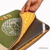 Inside view of a hand embroidered 15" Laptop sleeve in olive green and beige colours showcasing the soft padding and elastic corners for best protection of your laptop