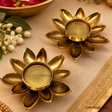 A pair of Handcrafted Brass Lotus T Light Holders kept on brocade cloth with jasmine flowers