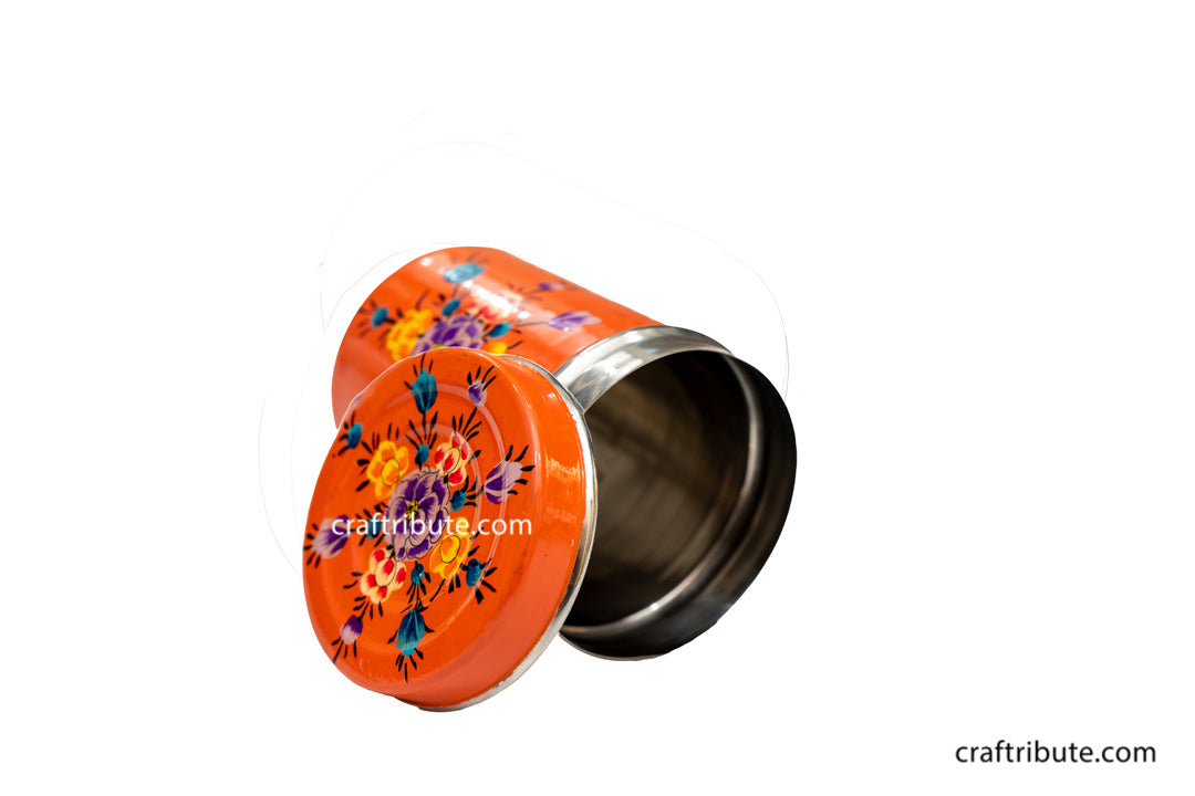artistic photo of a hand painted steel container in peach colour with delicate floral design