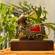 Decorative Dokra Nandi sculpture with gold and red ornamentation on a wooden pedestal