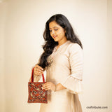 Pakko (Kutch Embroidery) floral design handbag in beautiful Red & Gold colours on a model