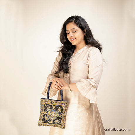Lady carrying a handbag with Scorpio (Vicchi) design in Kutch 'Neran' Embroidery style, in attractive Black & Gold combination 