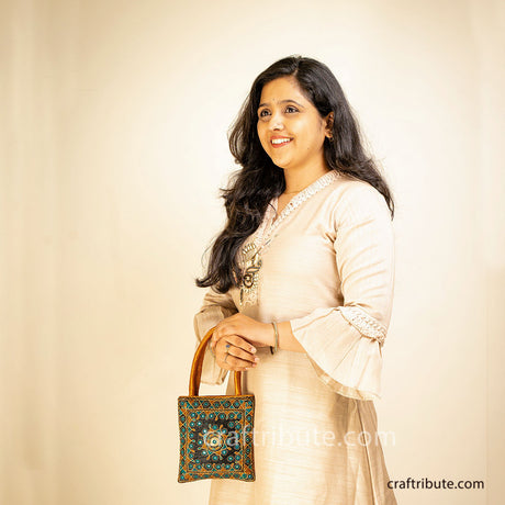 Girl flaunting Pakko Kutch Hand embroidered bag with Shining Star design in  rich Gold & Blue colours.