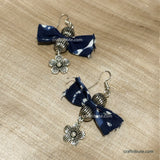 Upcycled indigo fabric butterfly earrings with silver accessories on a beige tussar silk background
