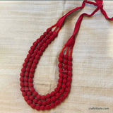 Red beaded necklace on a tussar silk background