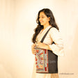 Girl carrying a black tote bag with Khudi Seba Kutch Embroidery with red & grey design 