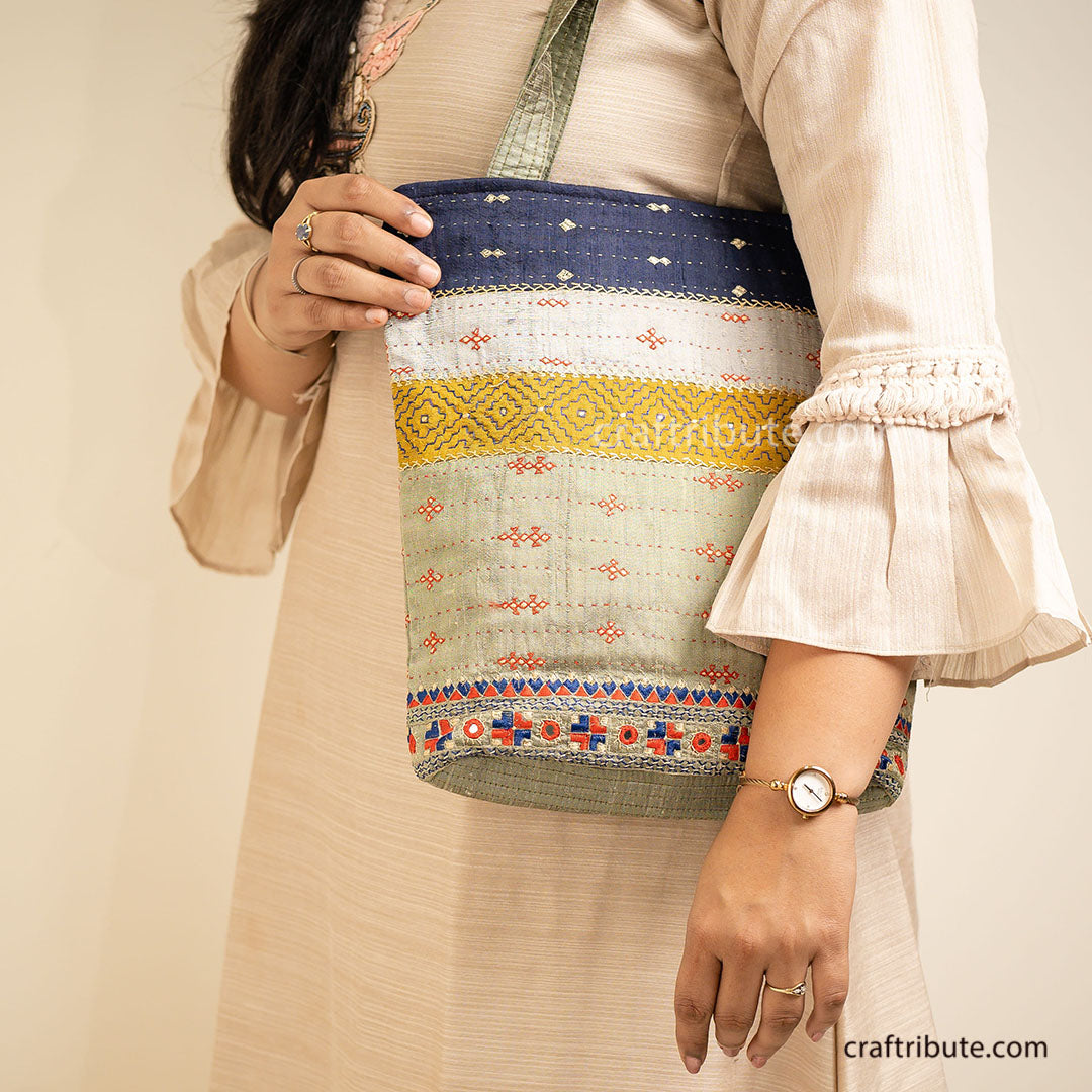 Girl holding a Kutch Khudi Sebha, Hand Embroidered Tote Bag with Stripes in attractive Green and Navy blue colour combinations