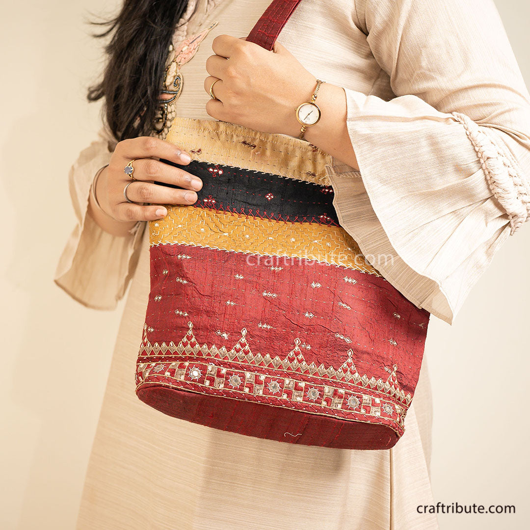Girl holding a Kutch Khudi Sebha, Hand Embroidered Tote Bag with attractive Red and Beige stripes design