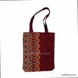 Front side of red tote bag with floral design in lilac & Gold, showcasing Ahir Kutch Hand embroidery