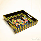 Decorative hand-painted Tikuli Art tray with artistic design depicting activities on a waterfront on a black ackground