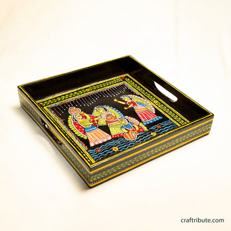Decorative hand-painted Tikuli Art tray with artistic design depicting activities on a waterfront on a black ackground