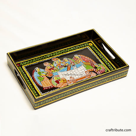 Wooden Serving Tray hand painted by women artisans from Bihar, depicting viollage women gathered around the well to draw water. Painted in vibrant colours  on a black background
